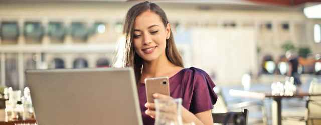 Woman Wearing Purple Shirt Holding Smartphone White Sitting on Chair